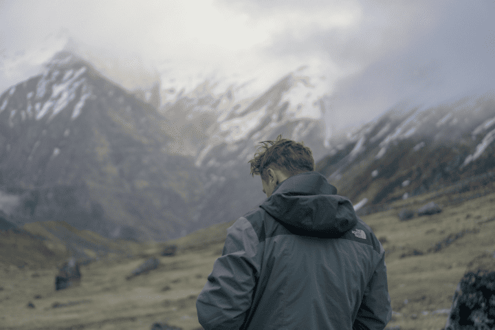 悪天候の中でレインウェアを着る男性