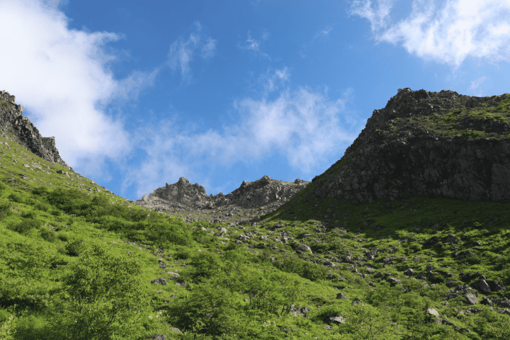 下山時に見た緑の斜面と岩峰