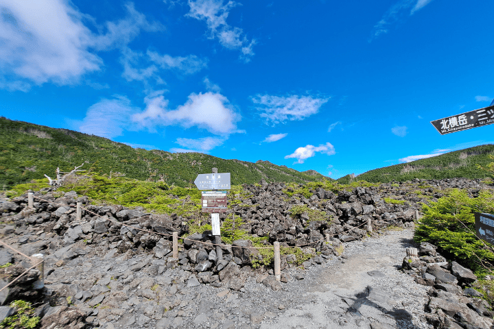 坪庭の岩場に立つ北横岳・三ツ岳方面の道標。ここが登山道の入口