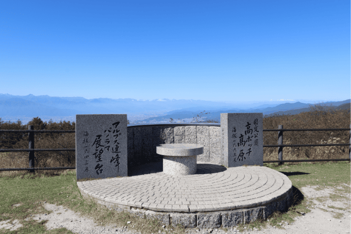 高ボッチ高原のアルプス連峰パノラマ展望台。石碑の奥に山並みが広がる